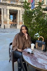 a lady in a brown wool coat and a pair of black leather pants